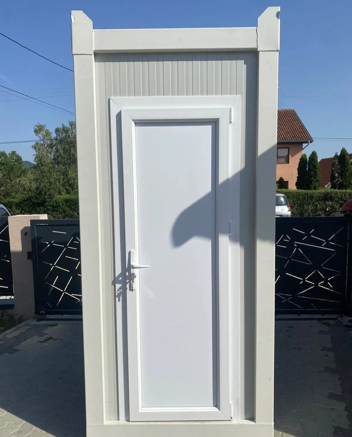 White flushing restroom cabin on a driveway